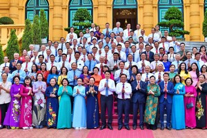 国家主席梁强（前中）同全国模范励学会干部代表团在主席府前合影理念。（图：越通社）