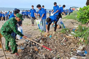 共青团员们一同在本市三胜坊沿岸海滩清理垃圾。（图：武雄）