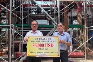 余建强（左）代表美加华人向霞漳会馆理事长沈金麟（右）移交修葺善款。