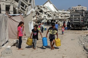 7月17日，巴勒斯坦儿童在加沙城取水。（图：新华社）