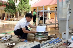 谅山省安平乡初中学校校长黄友阳检查哪些教学资料和教具仍可使用。（图：越通社）