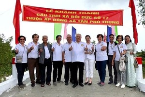 培德精舍会长、欧洲贸易公司董事长庄瑞雄（中）与代表们在新桥上合照留念。