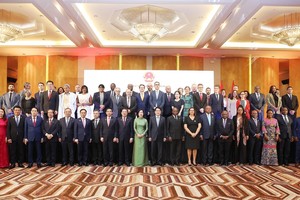 越南国家主席梁强与夫人出席越安建交50周年纪念活动，与各位代表合影。