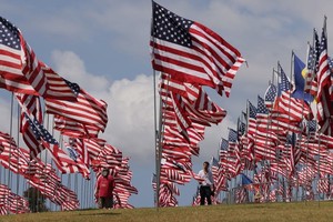 9月10日，在美国加利福尼亚州洛杉矶县马里布，人们从佩珀代因大学草坪上的“旗海”中走过。新华社照片