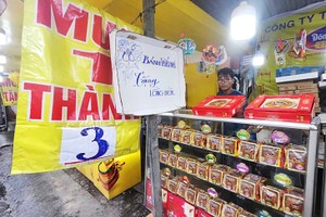 在原平盛郡乂靖苏维埃街的一家月饼销售地点挂出“买一送三”的促销标语。