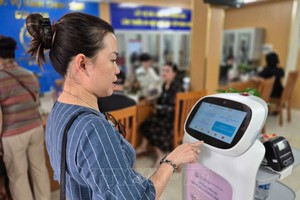 人民体验河内市南门坊人工智能机器人服务。