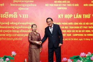 越南国防部副部长武明良上将与柬埔寨祖国发展团结阵线国家委员会主席梅森安亲切握手。