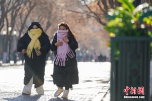 资料图：哈尔滨街头，市民身着厚衣物出行。