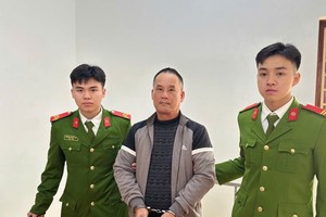 嫌犯段文创（灰色衣）在公安机关。