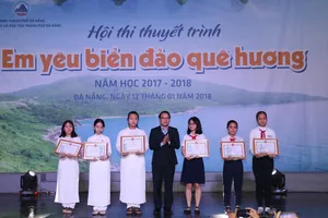Ông Nguyễn Đình Vĩnh, Giám đốc Sở GD-ĐT TP Đà Nẵng trao Giấy khen cho các học sinh đoạt giải nhất cuộc thi “Em viết về Đà Nẵng – Thành phố môi trường”