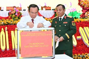 在第一届胡志明市军事党部大会上，市委书记、市军事党委书记阮文年捐款协助受灾同胞克服自然灾害和洪涝后果。