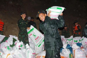 官兵搬运沙袋，用于加固堤岸。