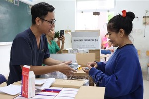 向洪涝灾区民众发放药品。