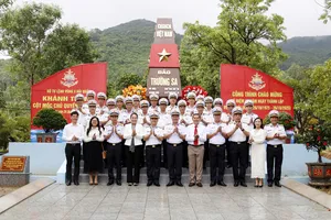 Các đại biểu chụp ảnh lưu niệm bên công trình mô hình cột mốc chủ quyền đảo Trường Sa tại Bộ Tư lệnh Vùng 3 Hải quân