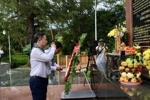  胡志明市市委宣教与民运处主任杨英德在杭胶陵园上香。 