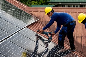 来自一家德菲合资的太阳能供应与安装公司的工作人员，正在菲律宾马尼拉的一户住宅安装太阳能电池板。