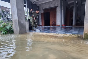 河靖省锦裔乡居民洪水退去后清理房屋。 