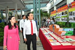 胡志明市市委书记陈留光参观南圻起义日书籍与资料展区。 