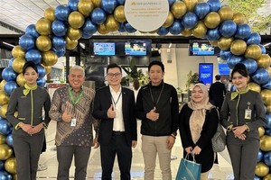 越航驻印尼首席代表和乘坐雅加达至河内直达航班的乘客合影。图自越通社 