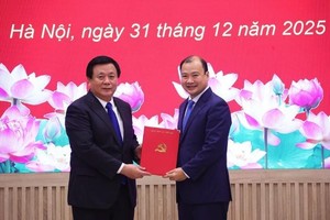 党中央政治局委员、党委书记、胡志明国家政治学院院长、中央理论委员会主席阮春胜教授、博士(左)向黎海平副教授、博士颁发《决定》。