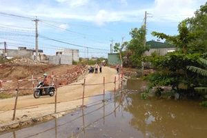 Nước thoát lũ tràn lên đường tạm.