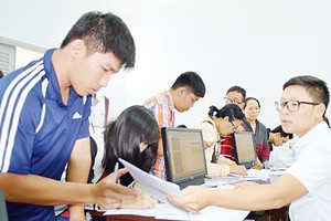 Students complete aperwork to applyfor the exam (Photo: SGGP)