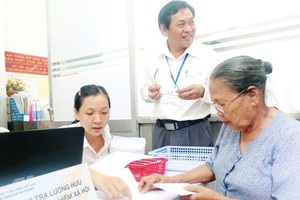 The old woman receives social insurance premium at an agency in HCMC (Photo: SGGP)