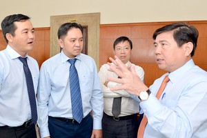 Chairman of the HCMC People’s Committee Nguyen Thanh Phong (R) talks to delegates at the 10th conference of the 10th city Party Committee on June 28 (Photo: SGGP)