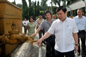 Chairman Nguyen Thanh Phong sees made in Vietnam gasification furnace, a technology that turns trash into a fuel, at Go Cat landfill site (Photo: SGGP)