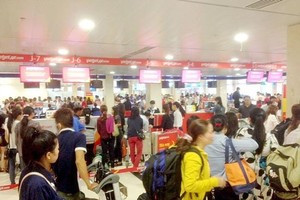 Passengers wait for their turns at airport check-in counters (Photo: SGGP)