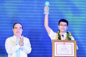 HCMC Party Chief Nguyen Thien Nhan congratulates young citizen Nguyen Thanh An at a ceremony honoring ten outstanding young citizens of 2017 on January 1 (Photo: SGGP)