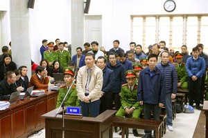 Trinh Xuan Thanh (standing in white jacket), and accomplices listen to the prosecutor’s arraignment. (Photo: VNA/VNS)