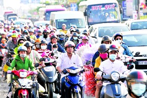 People from the Mekong Delta streaming back to HCMC in National Highway 1A, Binh Chanh district on February 20 (Photo: SGGP)
