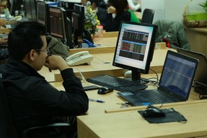 Investors watch market movements at the Military Bank Securities (MBS) trading floor. (Photo: VNS)
