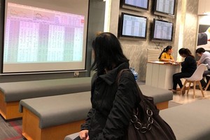 An investor follows transactions at Saigon Securities Inc (SSI) in Hanoi (Photo: VNS)