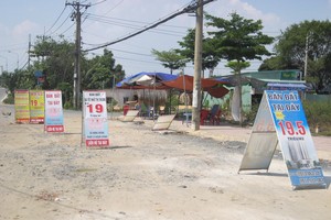 Boards offering property projects for sale in Nguyen Xien street, District 9 (Photo: SGGP)