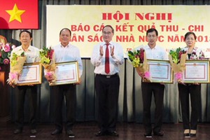HCMC Party Chief Nguyen Thien Nhan gives certificates of merit to representatives of 24 districts for well fulfilling their budget revenue mission in 2018 on January 3 (Photo: SGGP)