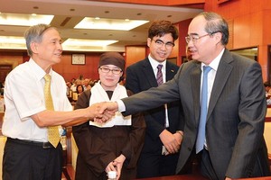 HCMC Party Chief Nguyen Thien Nhan shakes hands with an overseas Vietnamese at the meeting on January 24 (Photo: SGGP)
