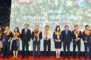 Standing Deputy Chairman of the Ho Chi Minh City People’s Committee Le Thanh Liem and SGGP’s editor in chief Nguyen Tan Phong give the Most Favorite Vietnamese Brands Awards to enterprises. (Photo: SGGP)