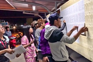 A male staff posts the list of 10,000 fired workers at My Phong company