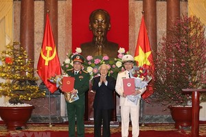 Party General Secretary and President Nguyen Phu Trong, who is also Secretary of the Central Military Commission and Chairman of the National Defence and Security Council, hands over the promotion decisions to the officers during a ceremony in Hanoi yeste