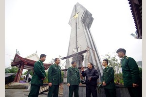 Mr. Hoang Nhu Ly (3rd, R) and soldiers at Po Hen Border Post talk together by Po Hen Monument (Photo: SGGP)