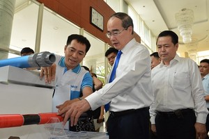 HCMC Party Chief Nguyen Thien Nhan learns about Vietnamese branded products (Photo: SGGP)