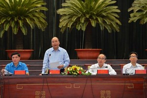 PM Nguyen Xuan Phuc (standing) at the meeting with highly-skilled workers in HCMC. (Photo: VNA)