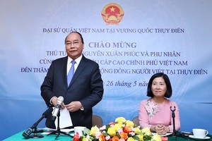 Prime Minister Nguyen Xuan Phuc (standing) speaks at the meeting with the Vietnamese Embassy staff and expatriates in Sweden. (Photo: VNA)