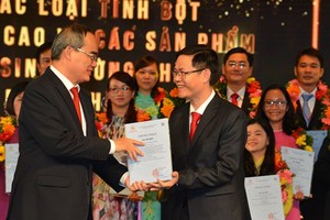 Secretary Nguyen Thien Nhan (L) gives the awards to the work ‘Study of the technological process of producing high resistant starches and low-sugar food produ from Vietnam's foods cts for obese and diabetic patients' (Photo: SGGP)