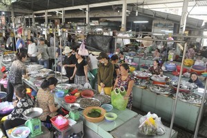 Busy tradings at Nguyen Van Troi traditional market. (Photo: SGGP)