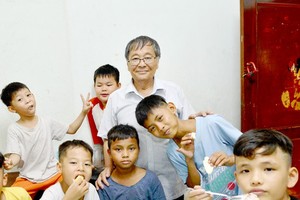Mr. Nguyen Thanh Tong and the children at Mai am Tre Xanh (Green Bamboo Shelter). (Photo: SGGP)