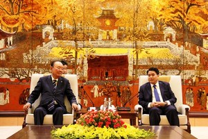 Chairman of the Hanoi municipal People’s Committee Nguyen Duc Chung (R) presents investment license to investor (Photo: VNA)