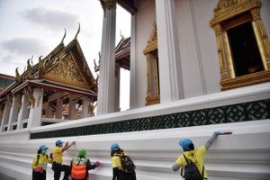 Volunteers and municipal workers clean surfaces at the Wat Suthat Thepwararam temple in Bangkok (Photo: AFP)